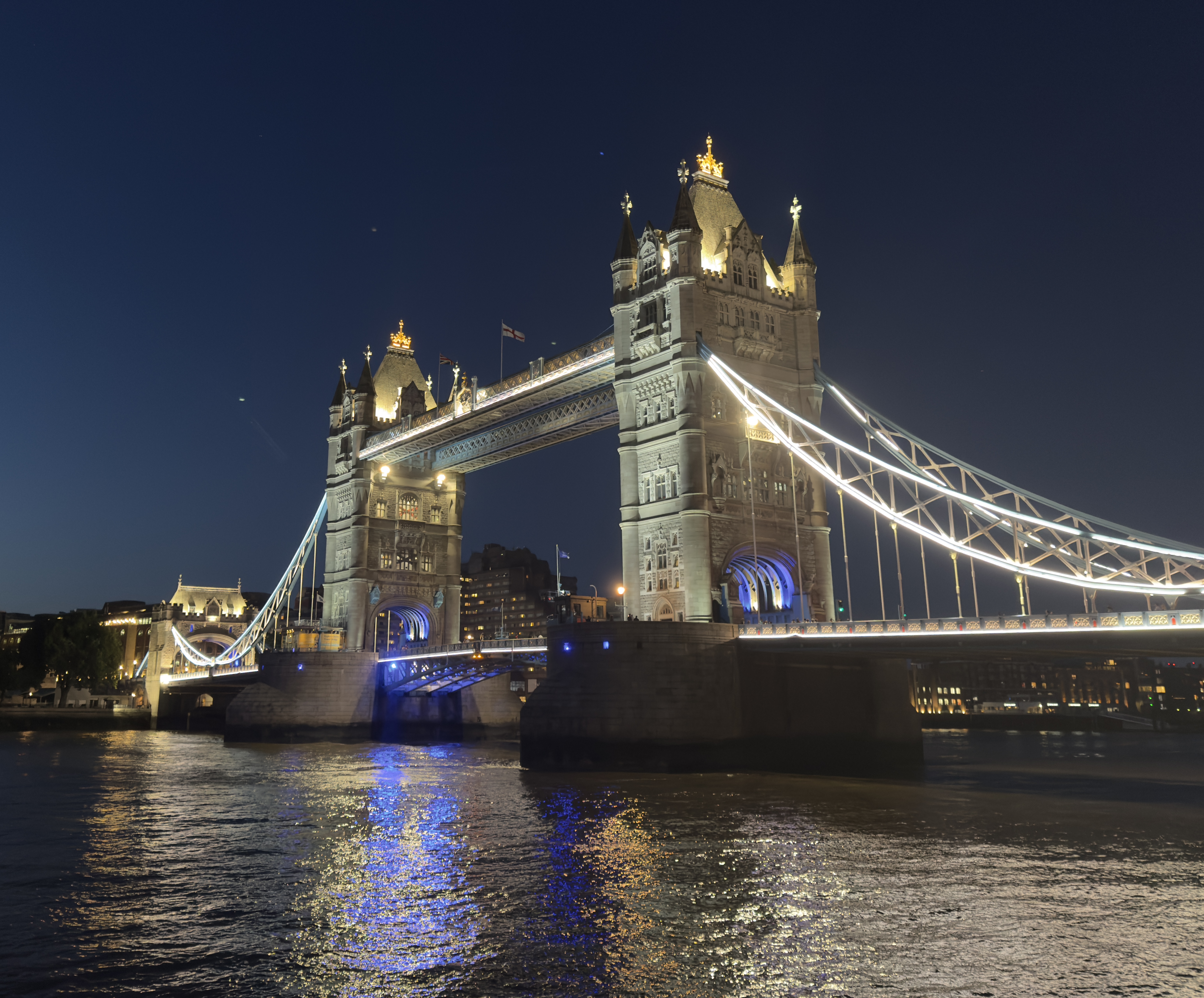 Illuminated towers of Tower Bridge above the river at night